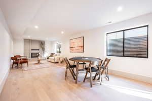 Dining space featuring light hardwood / wood-style flooring and a brick fireplace