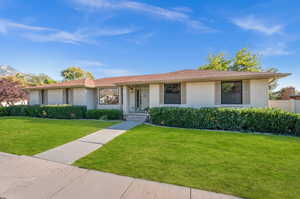 Single story home featuring a front lawn