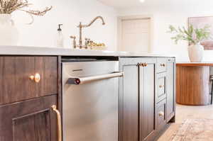 Room details featuring dark brown cabinets, light wood-type flooring, and stainless steel dishwasher