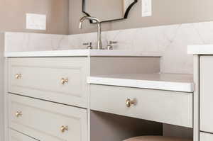 Room details featuring decorative backsplash and vanity