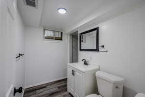 Bathroom featuring hardwood / wood-style floors, toilet, and vanity