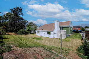 View of property exterior featuring a yard and a storage unit