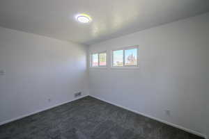 Carpeted empty room featuring a textured ceiling