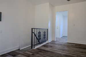 Hallway with dark hardwood / wood-style flooring