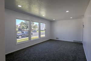 Carpeted empty room featuring a textured ceiling