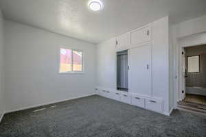 Unfurnished bedroom with a closet, carpet flooring, and a textured ceiling