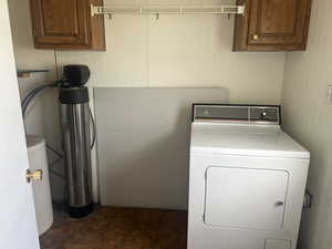 Laundry area with washer / dryer, wooden walls, and cabinets