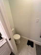 Bathroom featuring tile patterned flooring, toilet, and vanity