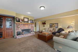 Carpeted living room featuring a brick fireplace