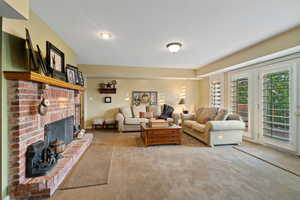 Carpeted living room featuring a brick fireplace