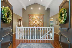 Foyer entrance featuring beamed ceiling, high vaulted ceiling, and dark hardwood / wood-style flooring