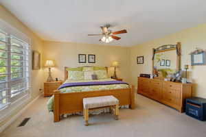 Bedroom with ceiling fan and light carpet