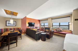 Carpeted living room with a textured ceiling and a tray ceiling