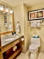 Bathroom with vanity, toilet, and tile patterned floors