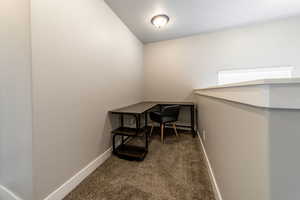 Carpeted office with lofted ceiling