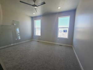 Carpeted empty room featuring ceiling fan and a textured ceiling