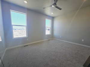 Unfurnished room with a textured ceiling, carpet, and ceiling fan