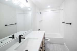 Full bathroom featuring vanity, toilet, and tiled shower / bath