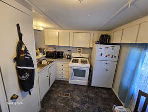 Kitchen with white cabinetry, white appliances, sink, and tasteful backsplash