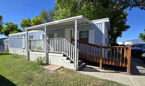 Manufactured / mobile home with a front yard and a deck