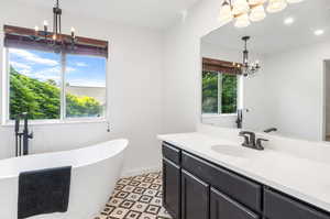 Updated primary bathroom with large soaking tub, walk-in shower, and granite countertops