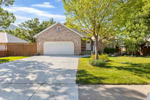 Front of home, with fenced RV parking and beautiful yard.