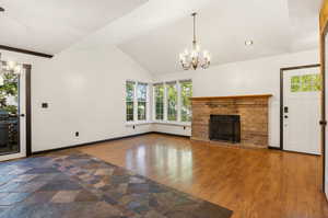 Dining area and living room with wood-burning fireplace, and doors leading out to deck.