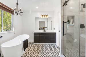 Updated primary bathroom with large soaking tub, walk-in shower, and granite countertops