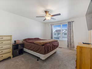 Carpeted bedroom featuring ceiling fan