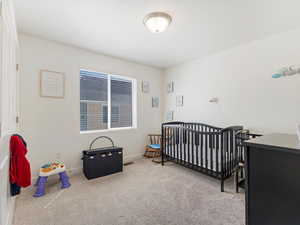 Carpeted bedroom with a crib