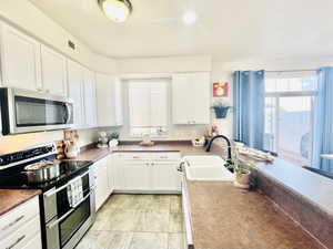 FRESHLY PAINTED CABINETS AND HARDWARE ADD TOO THE LIGHT AND AIRY FEEL OF KITCHEN