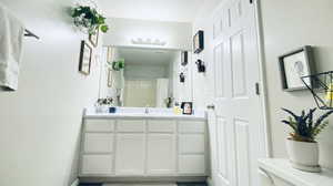 Bathroom featuring curtained shower, toilet, and vanity