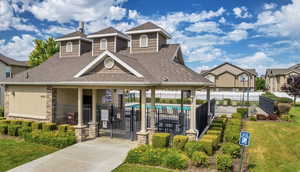 View of front facade featuring a front yard and a community pool