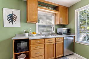 Kitchen with light tile patterned floors, stainless steel appliances, and sink