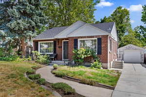 Bungalow-style house featuring a garage and an outbuilding