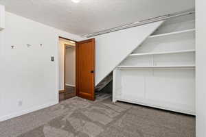 Unfurnished bedroom featuring a closet, carpet, and a textured ceiling