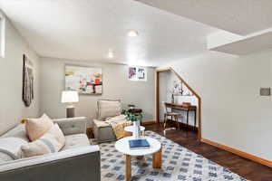 Living room featuring dark hardwood / wood-style floors and a textured ceiling