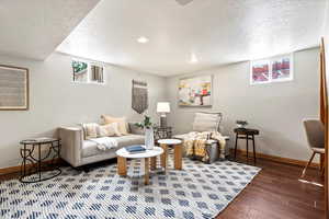 Living room with hardwood / wood-style flooring, a textured ceiling, and a healthy amount of sunlight