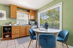 Kitchen with appliances with stainless steel finishes, light tile patterned floors, and sink