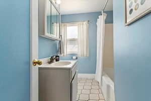 Bathroom with vanity and shower / bath combo with shower curtain