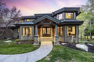 View of front of house with french doors and a lawn