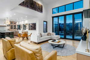 Living room featuring a high ceiling and light hardwood / wood-style floors