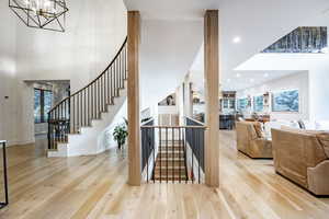 Stairway with a chandelier, hardwood / wood-style floors, and a wealth of natural light