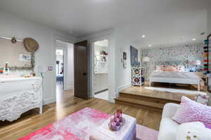 Bedroom featuring ensuite bathroom and light hardwood / wood-style flooring