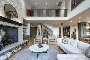 Living room featuring a high ceiling, hardwood / wood-style floors, and a fireplace