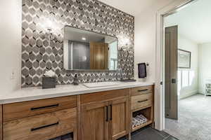 Bathroom featuring tasteful backsplash and vanity