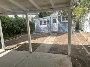 View of patio featuring garage with work shop.