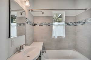 Bathroom featuring tiled shower / bath and sink