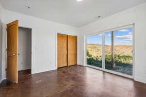 Unfurnished bedroom featuring a mountain view, a closet, and multiple windows