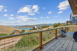 Wooden deck with a water and mountain view and a grill